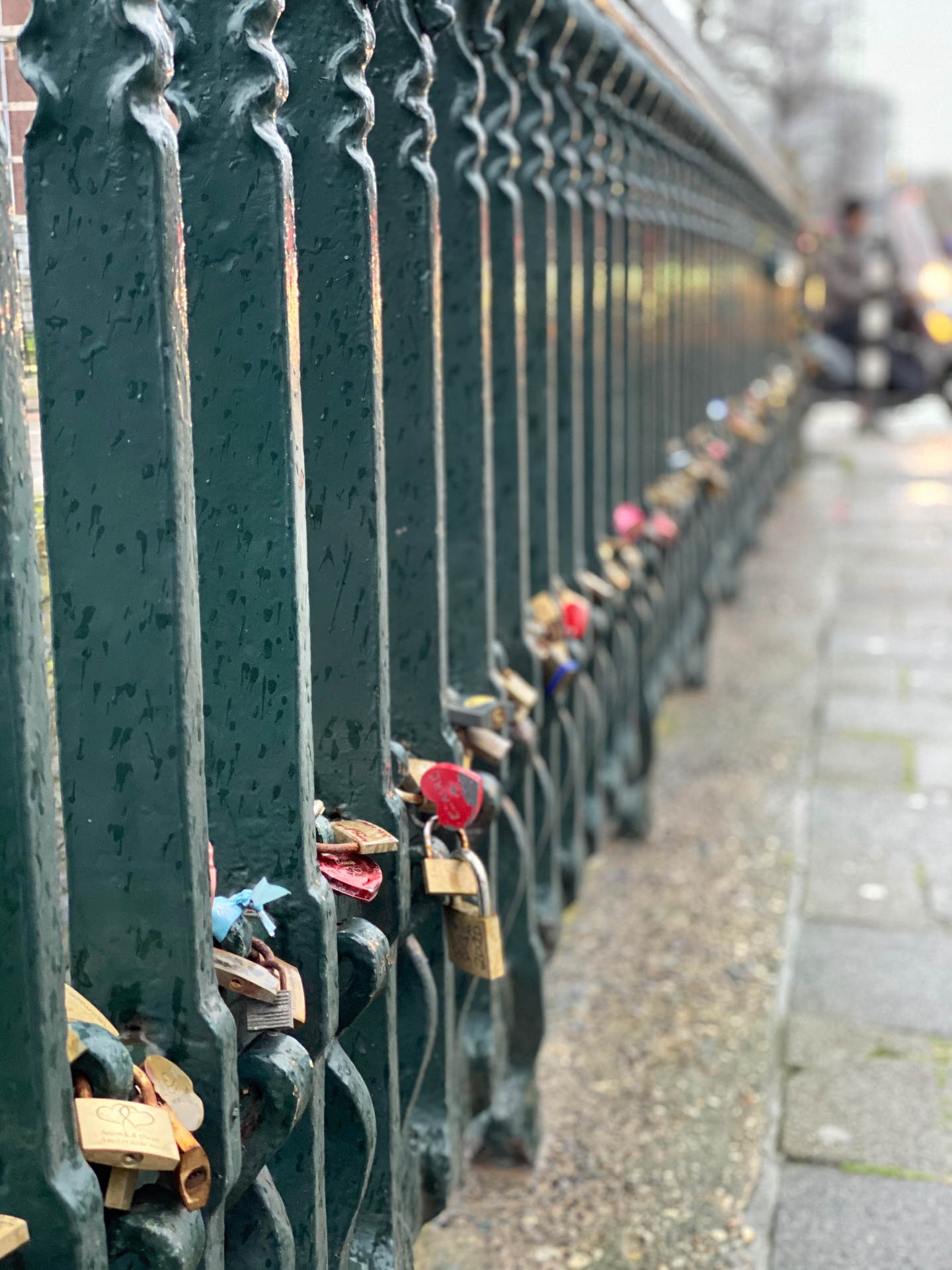 Love locks on a canal bridge railing in the rain